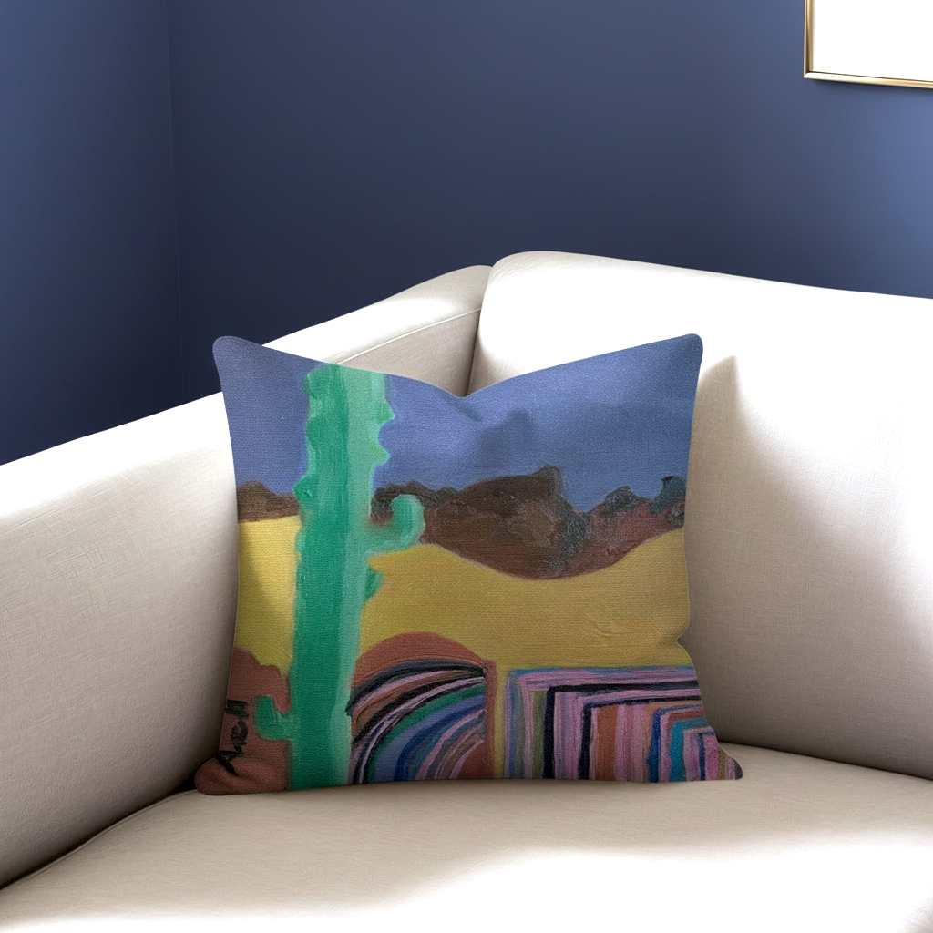 Decorative pillow with a colorful landscape design on a white couch against a blue wall.