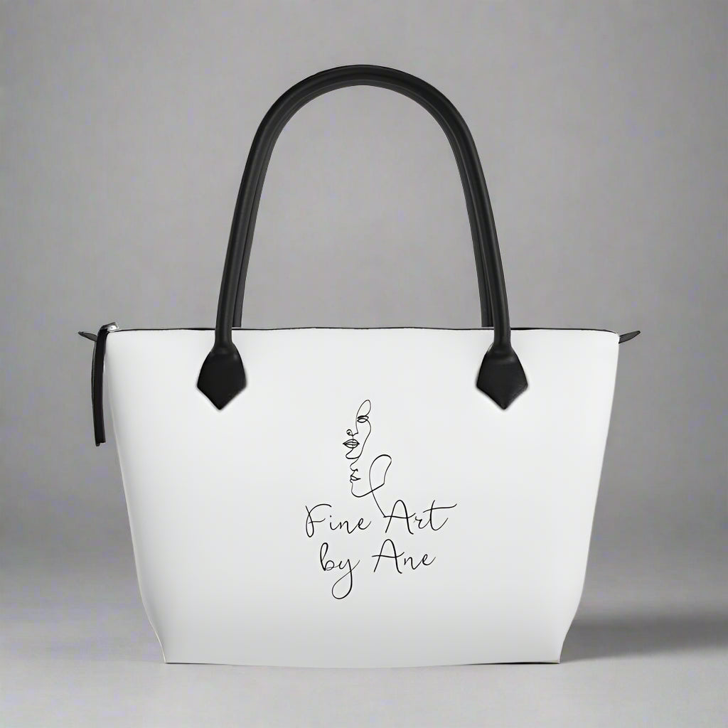 White handbag with black handles and 'Fine Art by Ane' text on a gray background