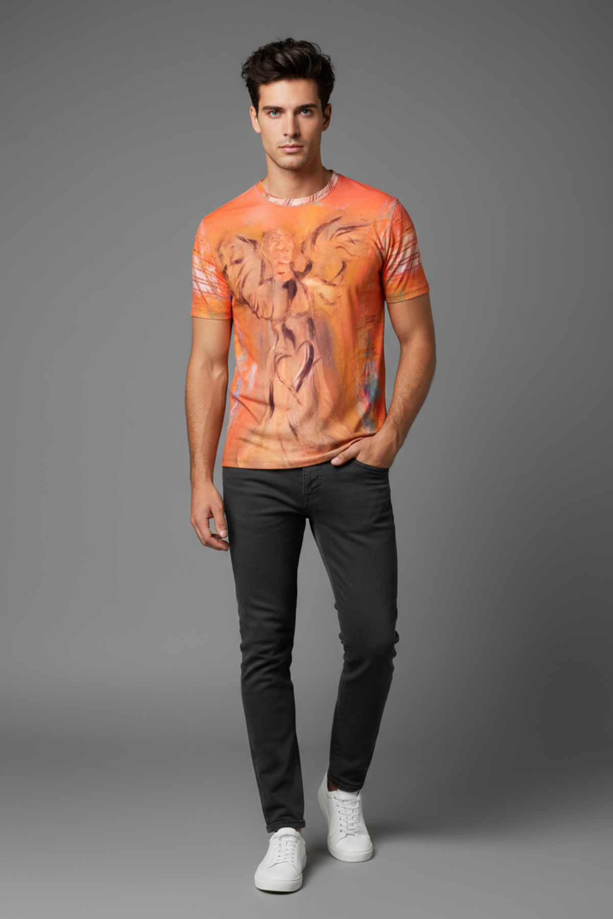 Man wearing an orange graphic t-shirt and black pants on a gray background