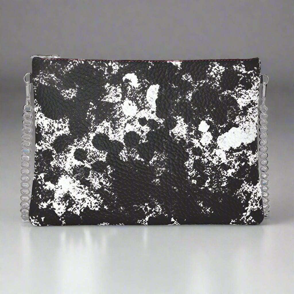 A black and white leather crossbody bag with a chain strap and a floral pattern.