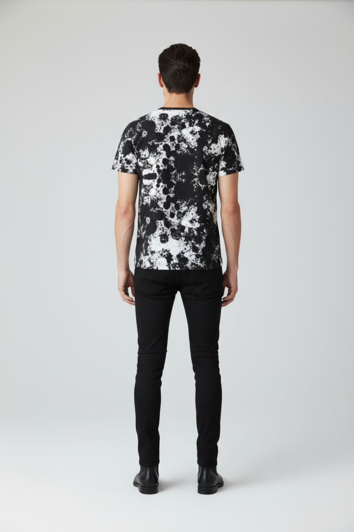 Person wearing a black and white patterned shirt on a plain background