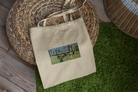 Beige tote bag with a printed design on a green surface