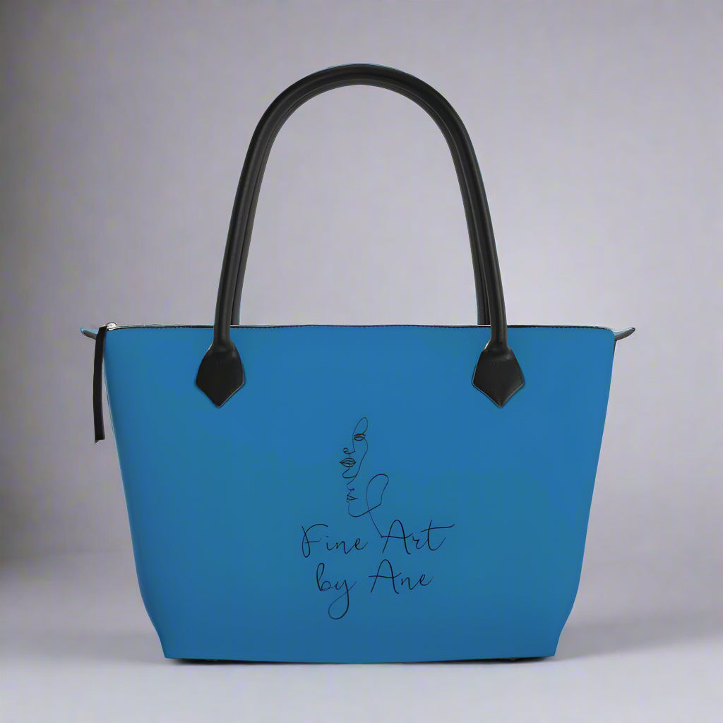 Blue handbag with black handle and 'Fine Art by Are' text on a gray background
