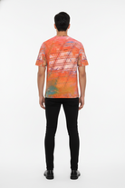 Person wearing a colorful abstract patterned shirt on a white background