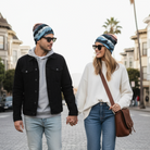 Two people walking hand-in-hand on a city street.