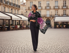 Woman walking on a cobblestone street in an urban setting with a floral shawl.