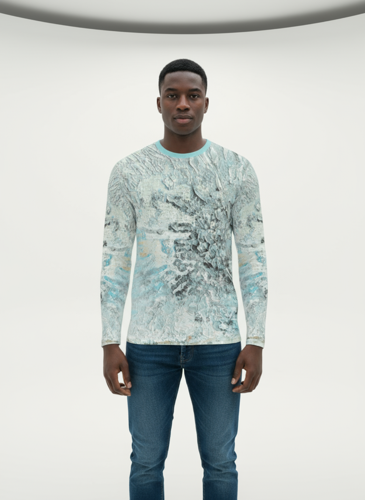 Man wearing a long-sleeve patterned shirt and jeans on a white background